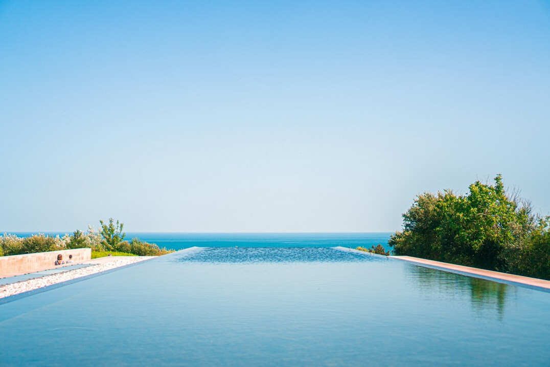 Modern minimalist villa with infinity pool overlooking the ocean